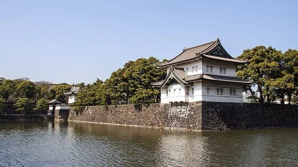 Traditional Japanese castle by water under blue sky Imperial Palace Tokyo Travel Guide